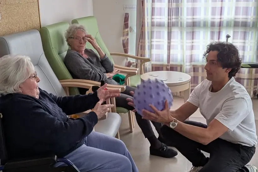 Exercice avec ballon auprès d'une résidente en fauteuil