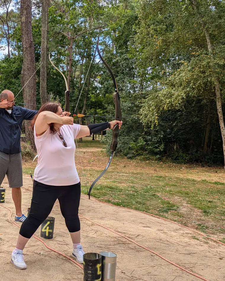 Tir à l'arc encadré, une participante en pleine visée